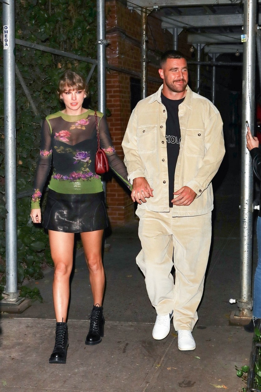 Taylor Swift și Travis Kelce în timp ce se plimbă pe stradă împreună și se țin de mână