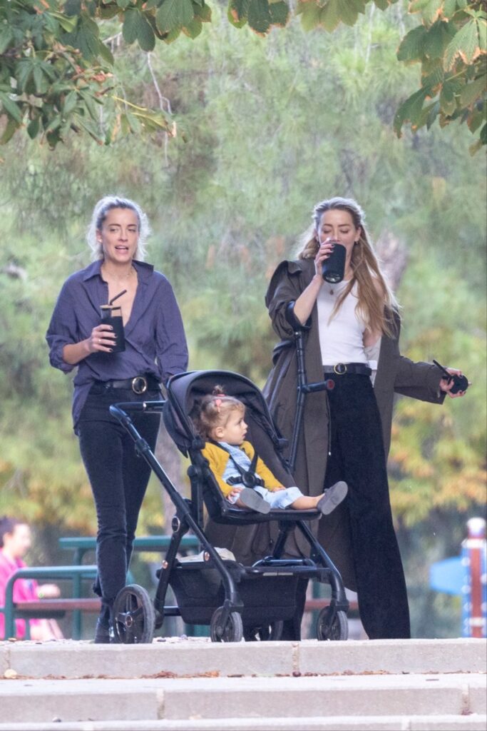 Amber Heard alături de sora sa, Whitney Henriquez, dar și de micuța Oonagh care este plimbată în căruț într-un parc din Madrid