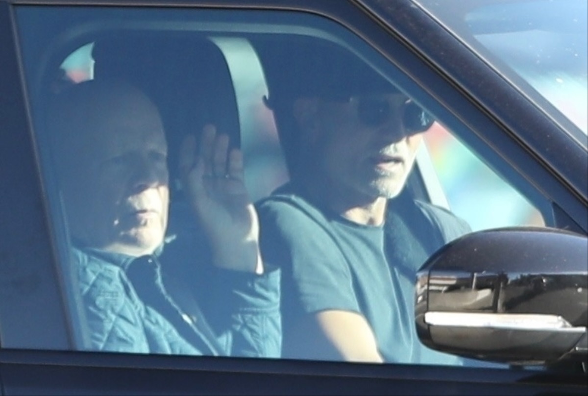 Bruce Willis într-o mașină neagră alături de un prieten în timp ce merg prin Los Angeles
