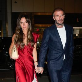 Victoria Beckham într-o rochie roșie alături de David Beckham care poartă costum și se îndreaptă la un restaurant din New York