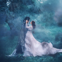 Fată frumoasă îmbrăcată într-o rochie de voal stă într-o pădure