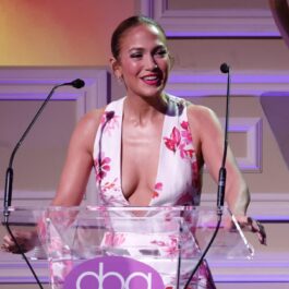 Jennifer Lopez într-o rochie cu imprimeu floral în timp ce vorbește la un pupitru