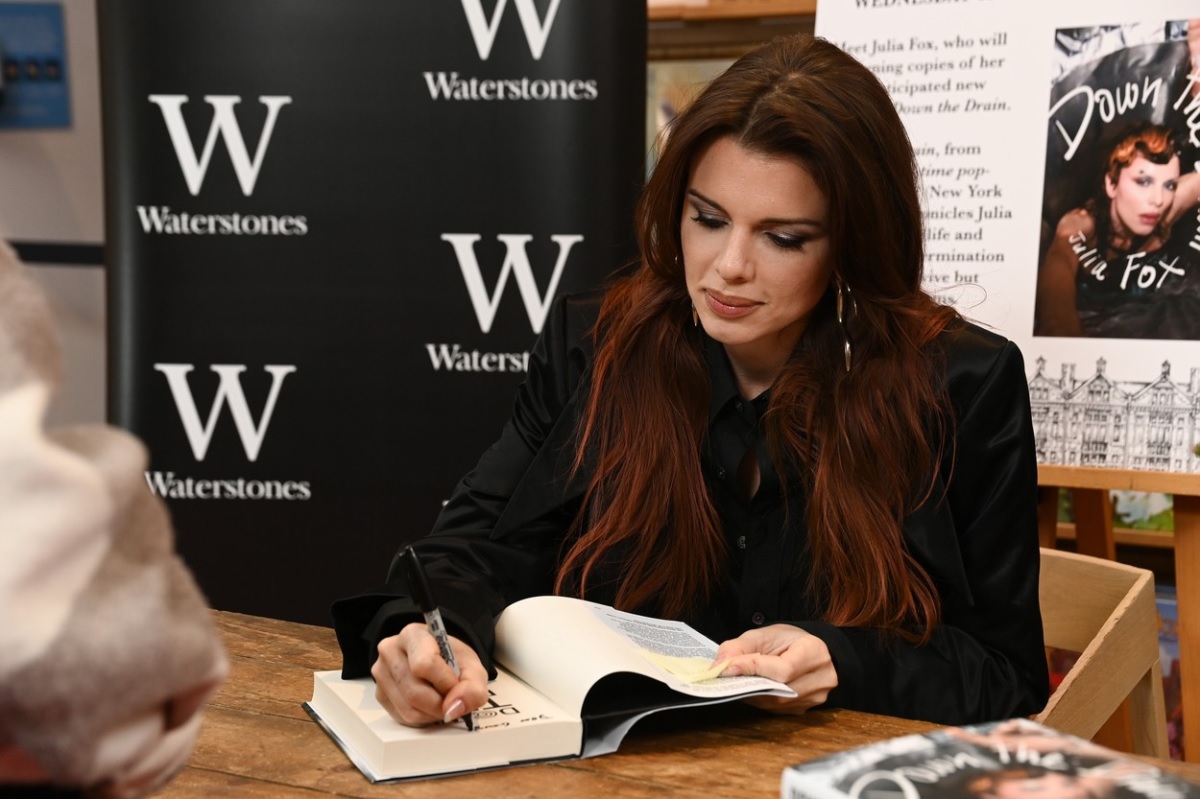 Julia Fox în timp ce semnează o carte la o întâlnire cu fanii