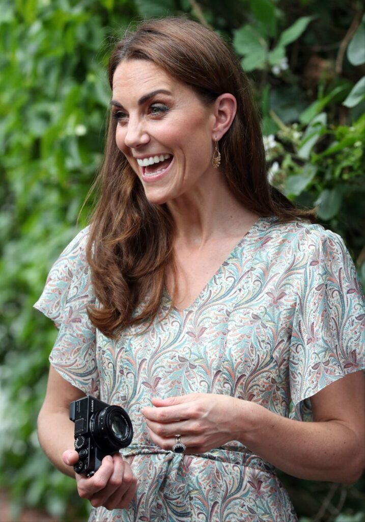 Kate Middleton în timp ce ține în mână un aparat foto