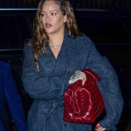 Rihanna, într-un palton gri, cu o geantă mare roșie