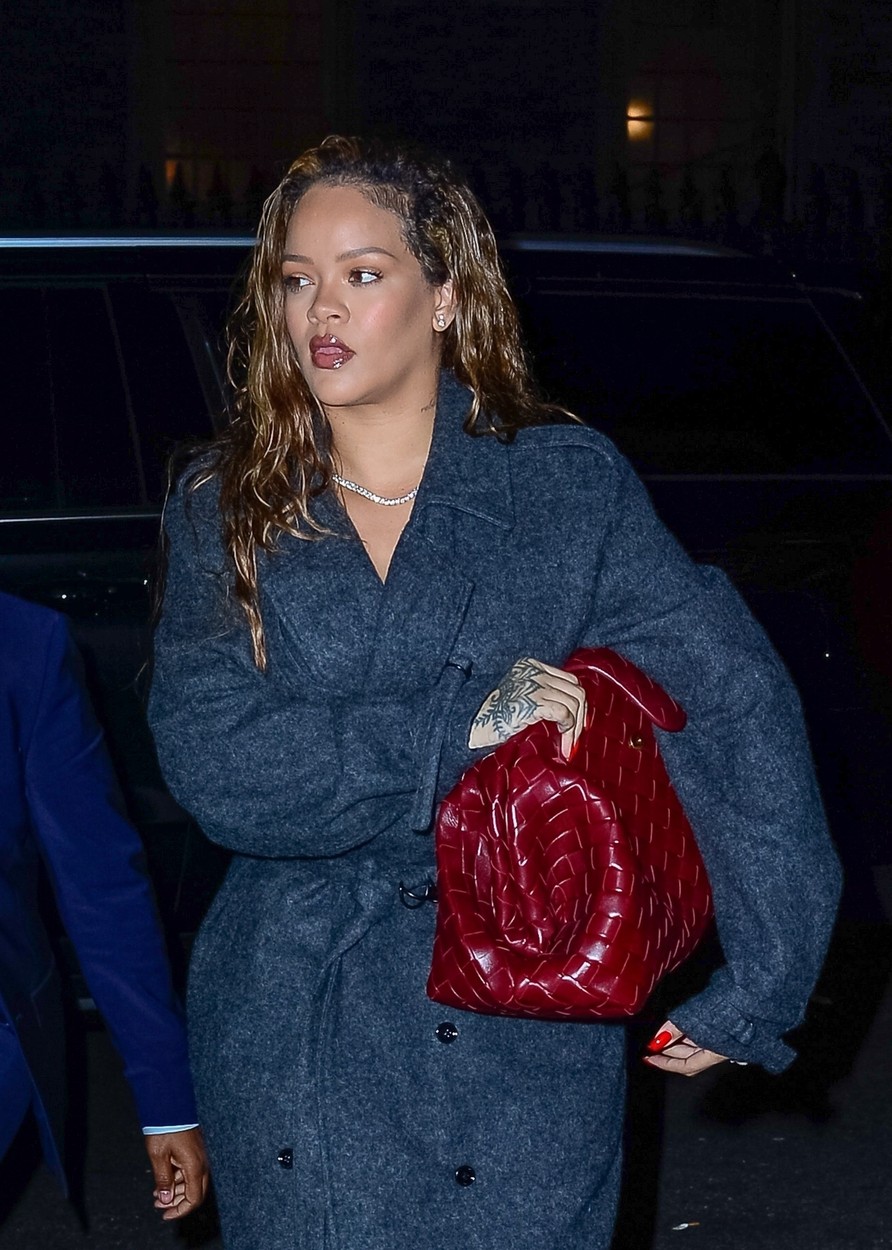 Rihanna, într-un palton gri, cu o geantă mare roșie