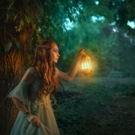 O femeie care luminează cu un felinar în pădure
