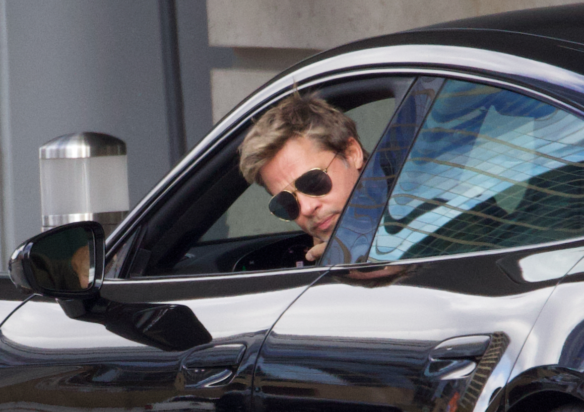 Brad Pitt, cu ochelari de soare la ochi, într-o mașină luxoasă