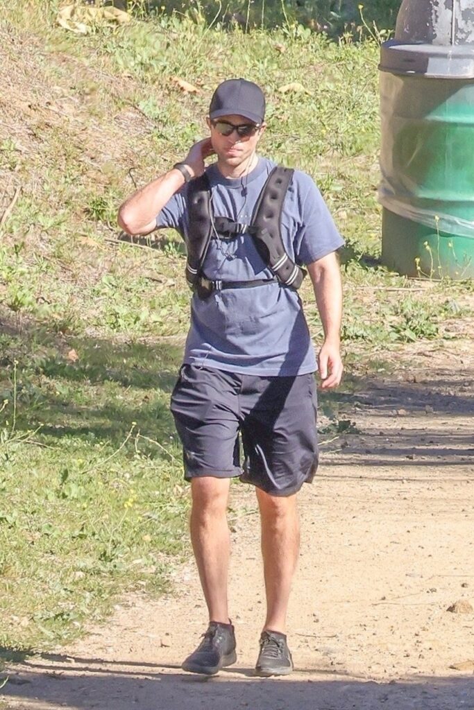 Robert Pattinson cu o vestă cu greutăți în timp ce urcă pe munte