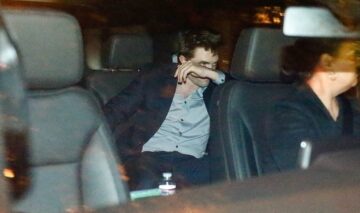 Robert Pattinson în timp ce se ferește de paparazzi într-o mașină