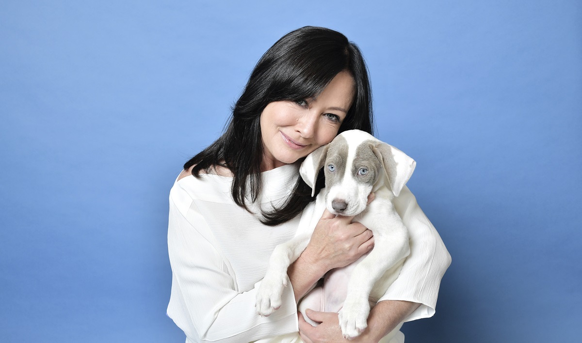 Shannen Doherty în timp ce ține un câine în brațe și pozează pentru un interviu