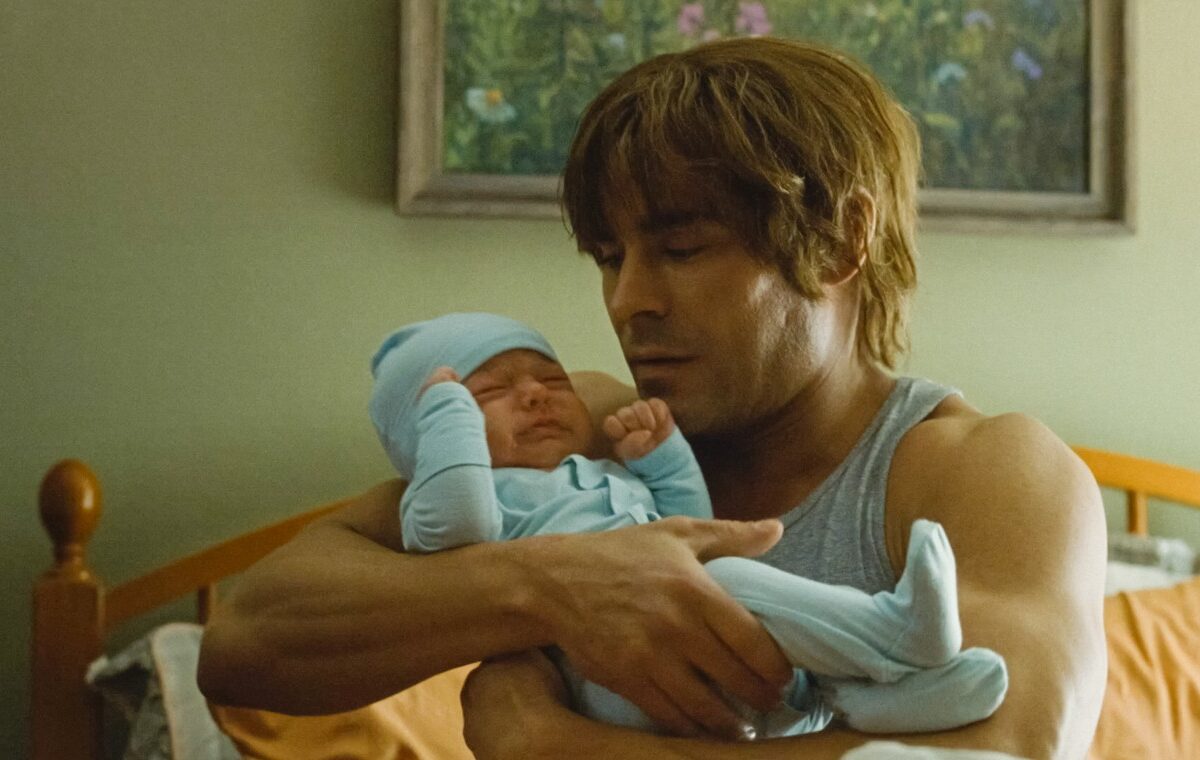 Zac Efron, imagini din filmul The Iron Claw, cu un bebeluș în brațe