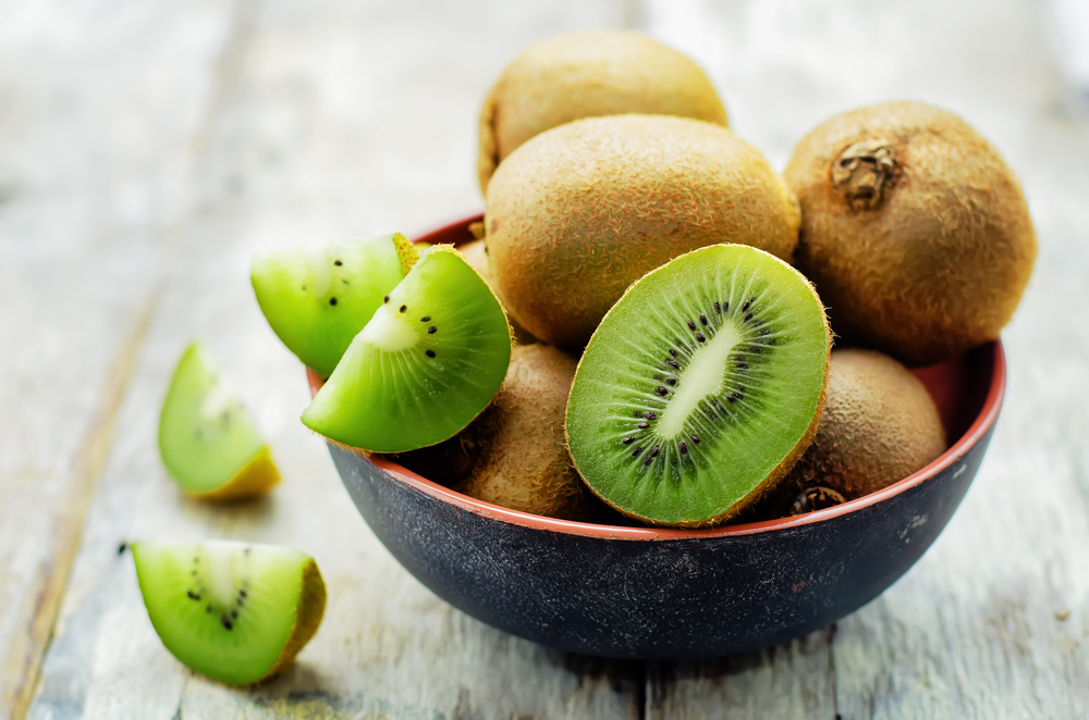 Un castron cu fructe de kiwi fotografiate pe un blat de culoare gri