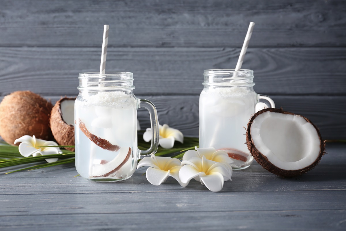 Două pahare pline cu apă de cocos care ajută la îmbunătățirea sănătății organismului