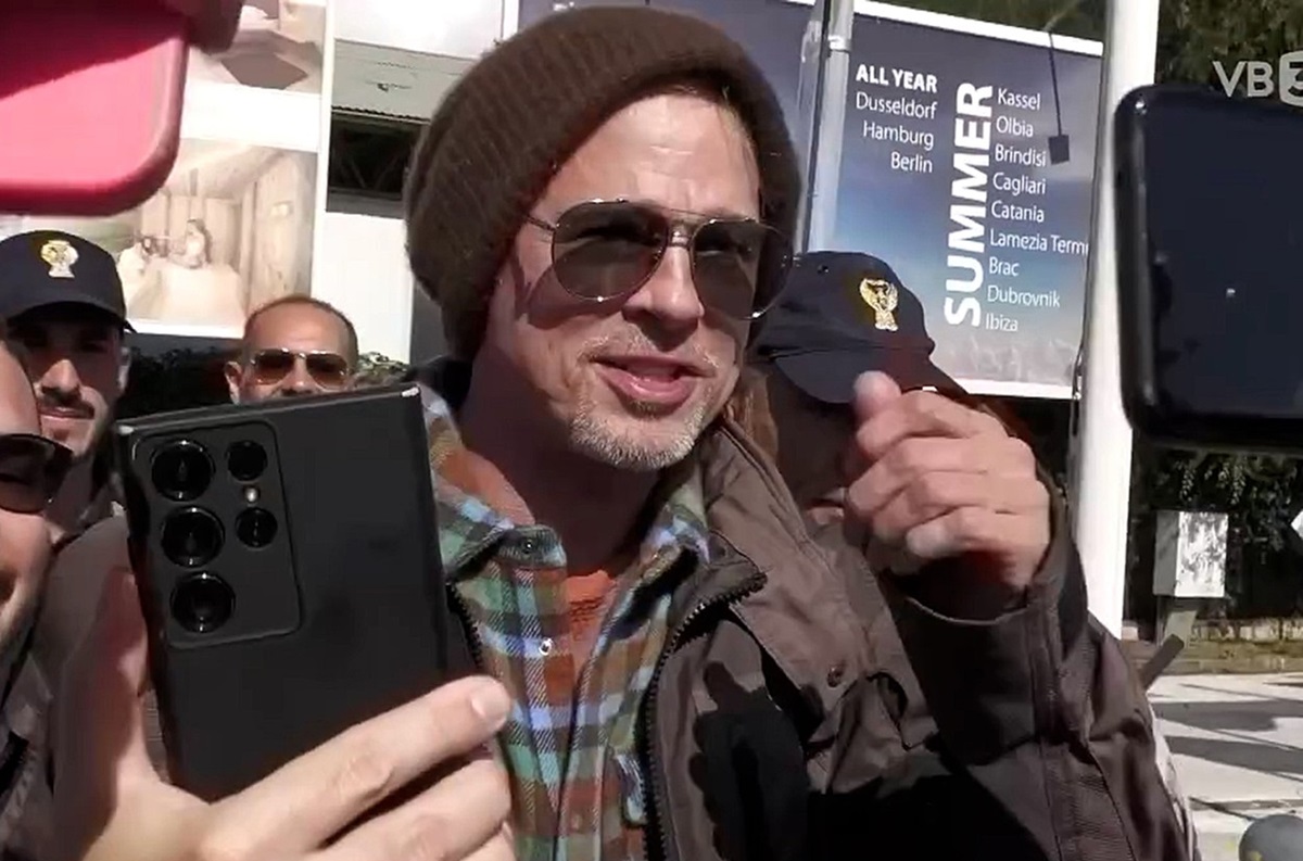 Brad Pitt în timp ce este întâmpinat de fani într-u aeroport
