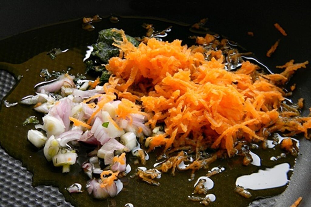 Ceapă cu usturoi și morcovi într-o tigaie cu ulei