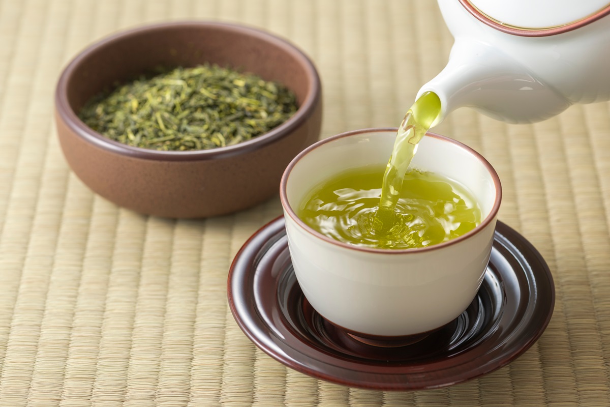 Două cești de ceai în care se află ceai verde pentru a ilustra beneficiile sale pentru sănătate