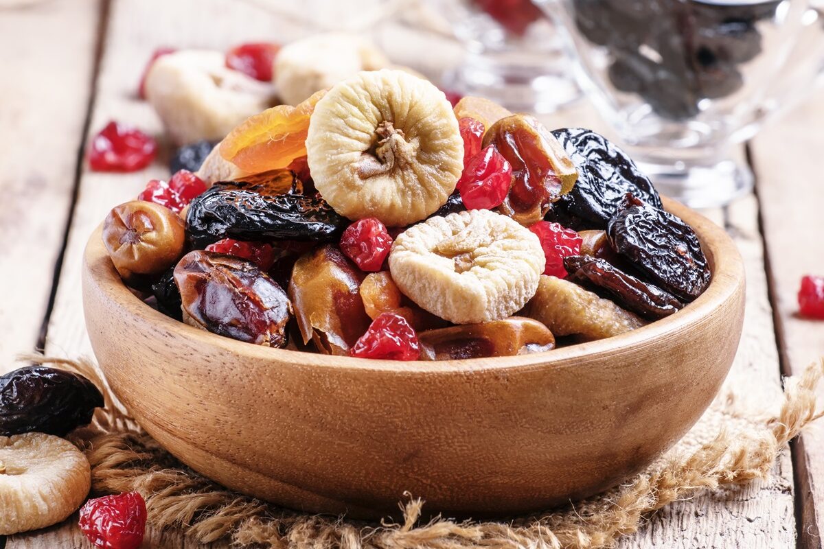 Un bol de lemn plin cu fructe uscate care sunt ideale pentru consum în timpul iernii
