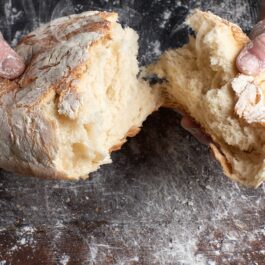 Pâine cu cartofi ruptă în două mâini