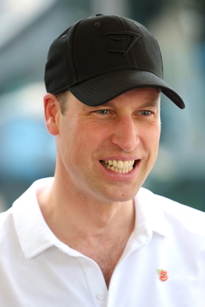 Prințul William, cu o șapcă neagră și un tricou alb, polo