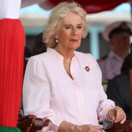 Regina Camilla într-o rochie albă în timp ce stă pe un scaun în cadrul turneului regal din Africa