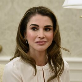 Regina Rania îmbrăcată într-un costum alb în timp ce vorbește despre căsnicia sa