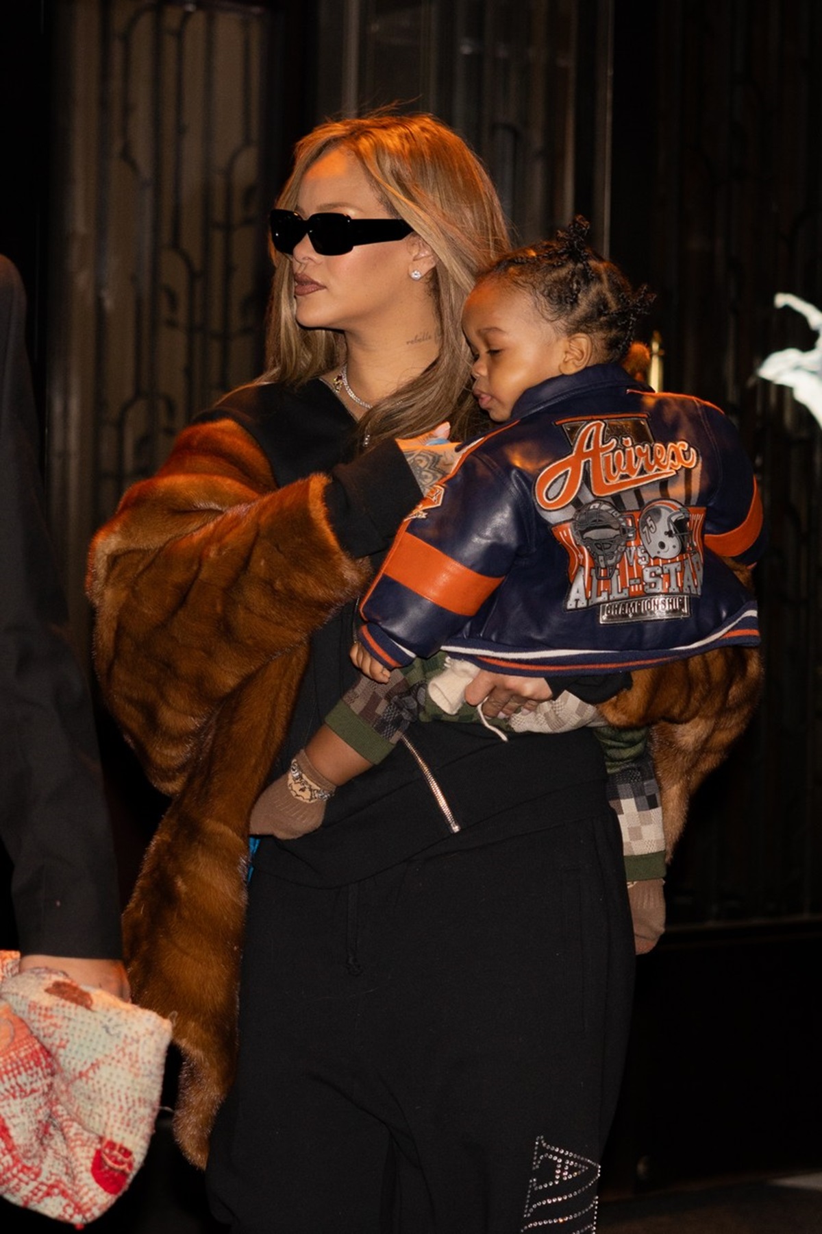 Rihanna care îl ține în brațe pe băiețelul său, RZA, în fața unui hotel din NEw York