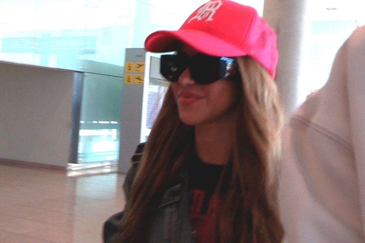 Shakira cu o șapcă roșie în timp ce părăsește aeroportul din Madrid