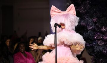 Sia cu o perucă roz și o fundă în timpul unui concert de la New York