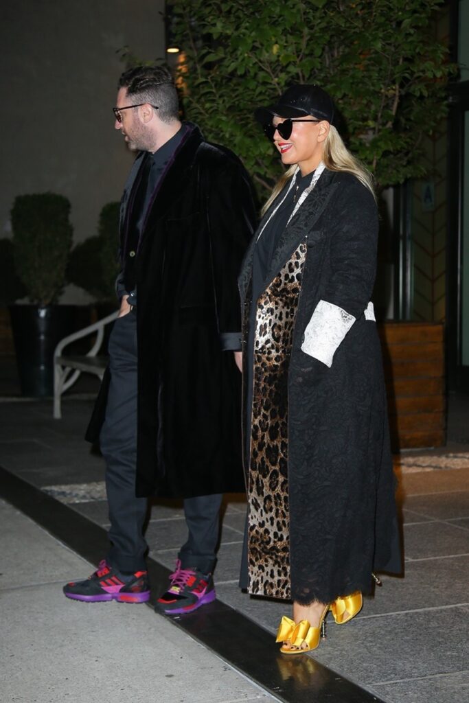 Sia într-o rochie cu imprimeu de leopard și o pereche de pantofi aurii