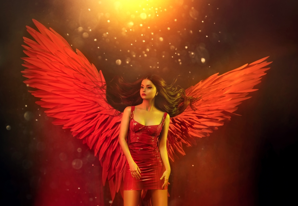 Fată frumoasă îmbrăcată cu o rochie roșie și cu aripi roșii pe un fundal închis la culoare