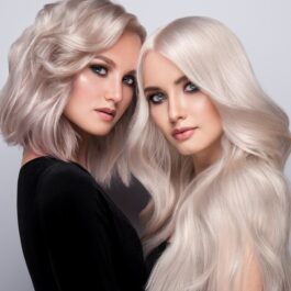 Două femei care stau una lângă cealată având părul scurt și lung pentru a ilustra trucul simplu care te ajută să te decizi dacă îți stă mai bine cu părul lung sau cu părul scurt