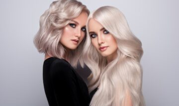 Două femei care stau una lângă cealată având părul scurt și lung pentru a ilustra trucul simplu care te ajută să te decizi dacă îți stă mai bine cu părul lung sau cu părul scurt