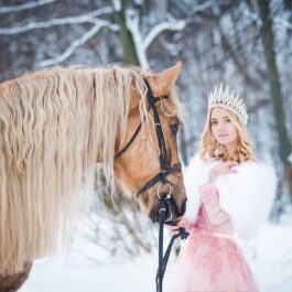 O prințesă cu coroniță, zodia norocoasă a lunii decembrie 2023, care ține în frâu un ponei într-o pădure înzăpezită