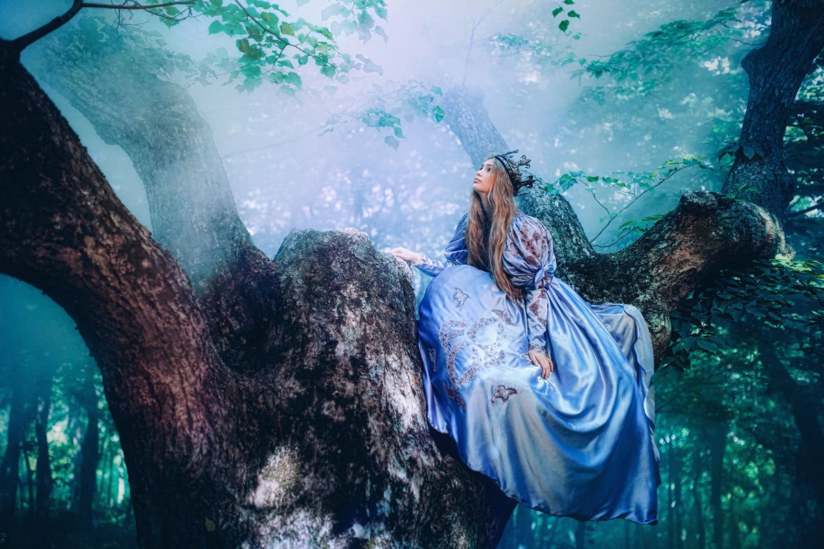 o femeie frumoasă care poartă o rochie albastră și stă într-un copac privind o pâclă de ceață pentru a ilustra una dintre cele trei zodii care iau decizii pripite