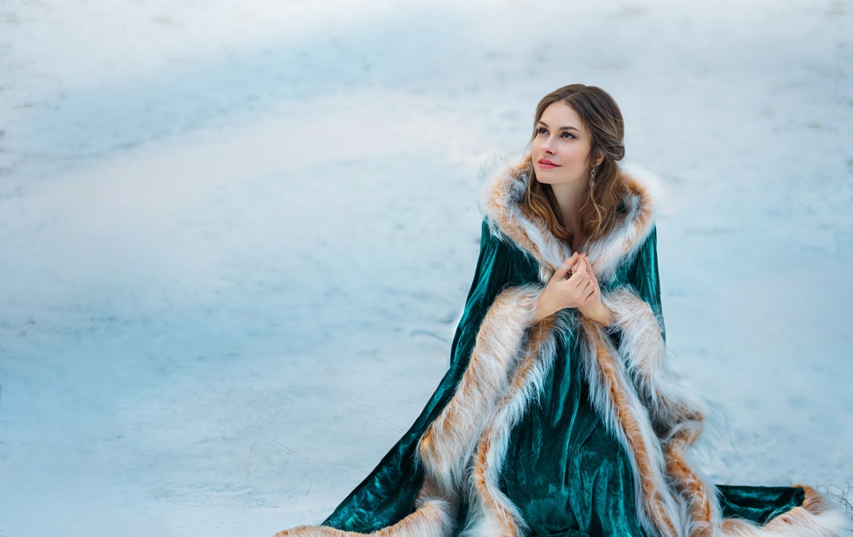O femeie frumoasă care poartă o faină de blană verde și stă pe un câmp plin de zăpadă pentru a ilustra una dintre cele trei zodii care își vor mărturisi iubirea pe 27 noiembrie 2023