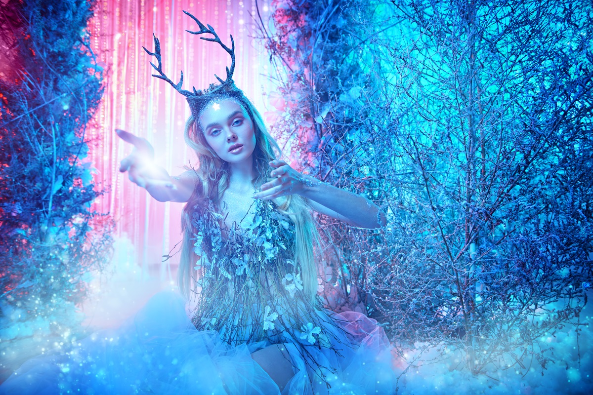 O femeie frumoasă care poartă o rochie de iarnă și stă într-un peisaj feeric pentru a ilustra una dintre cele patru zodii care iubesc iarna
