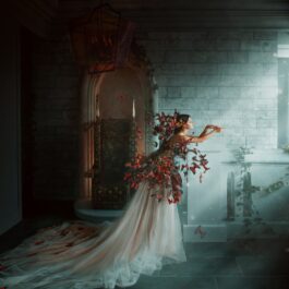 O femeie frumoasă care poartă o rochie albă și este înconjurată de frunze și flori într-o cameră de castel ilustrând una dintre cele trei zodii care trec greu peste o despărțire