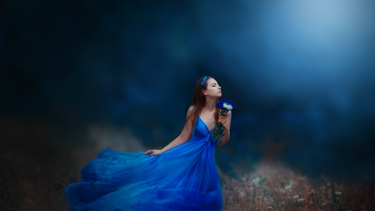 O femeie frumoasă care poartă o rochie albastră și ilustrează una dintre cele trei zodii cu o personalitate rară