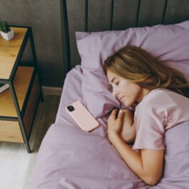 O femeie care doarme cu telefonul lângă cap
