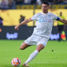 Cristiano Ronaldo, pe terenul de fotbal, în timp ce șutează în minge