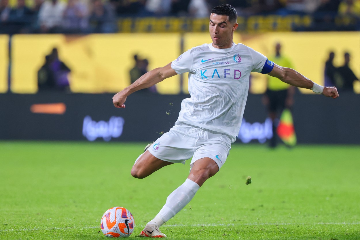 Cristiano Ronaldo, pe terenul de fotbal, în timp ce șutează în minge