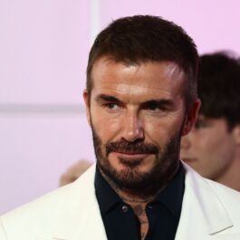 David Beckham, într-o cămașă neagră și un sacou alb, la un eveniment