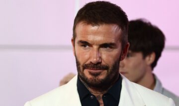 David Beckham, într-o cămașă neagră și un sacou alb, la un eveniment