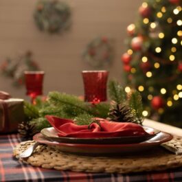O masă frumos decorată de Crăciun, cu un cadou alături