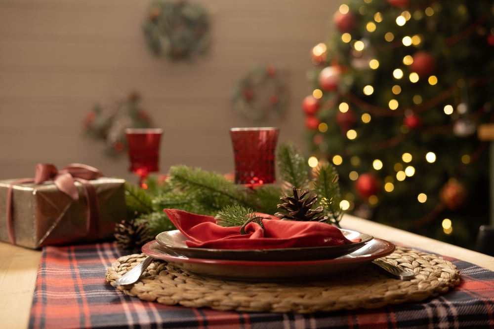 O masă frumos decorată de Crăciun, cu un cadou alături