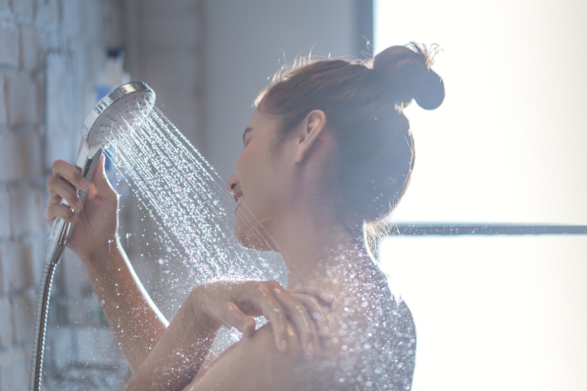 O femeie frumoasă care își face un duș lung pentru a ilustra cât de des e recomandat să faci duș