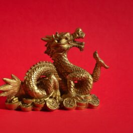 Un dragon auriu fotografiat pe un fundal roșu