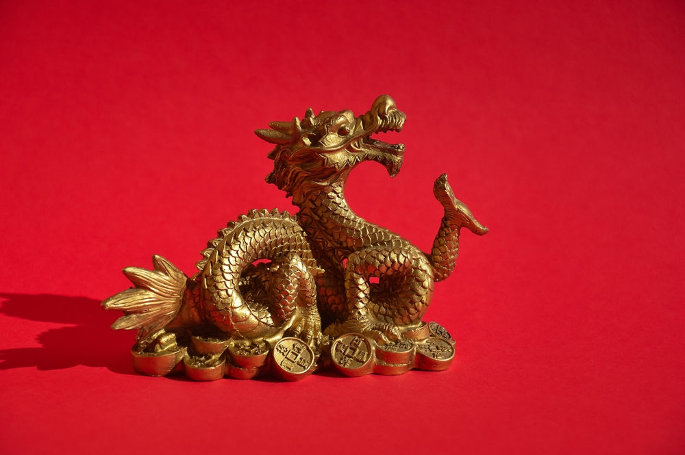 Un dragon auriu fotografiat pe un fundal roșu