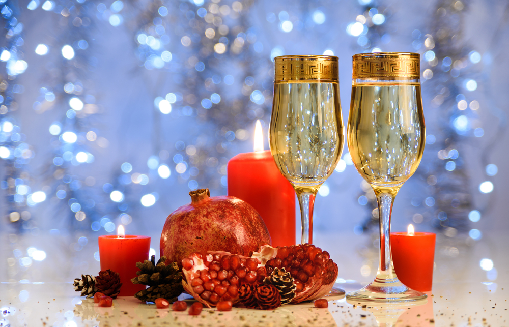 Rodie pe o masă de Anul Nou cu două pahare de șampanie